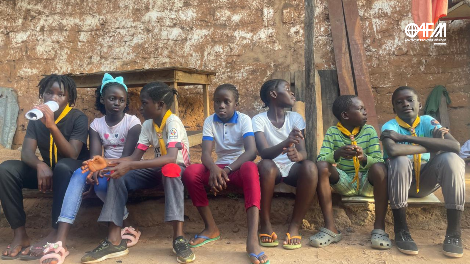 Desgosto e Esperança: Uma Mensagem de Conforto. Desbravadores sentados juntos em uma calçada.